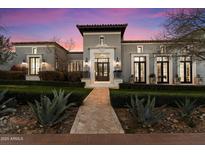 Elegant gray home featuring manicured landscaping, a brick pathway, and a grand entryway with decorative stone accents at 10244 E Hualapai Dr, Scottsdale, AZ 85255