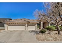 Charming home showcasing a well-manicured yard, beige paint, and a three-car garage for ample parking at 11046 E Naranja Ave, Mesa, AZ 85209