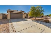 Charming single-story home with a two-car garage, concrete driveway and desert landscaping at 14787 W Aster Dr, Surprise, AZ 85379