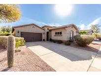 Inviting single-story home with a long driveway, desert landscaping, and a welcoming entrance at 16549 W Rowel Rd, Surprise, AZ 85387