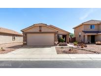 Charming single story home with desert landscaping, an attached two car garage and covered front porch at 22569 W Lasso Ln, Buckeye, AZ 85326