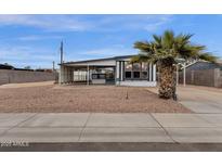 Charming single-story home featuring a carport, desert landscaping, and mature palm tree at 2570 W Scenic St, Apache Junction, AZ 85120