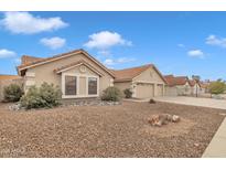 Single-story home with a neutral color scheme, red tile roof, and a gravel yard with green landscaping at 3015 E Nora St, Mesa, AZ 85213