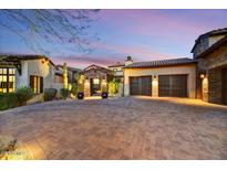 Paver driveway leads to a home with a two-car garage and beautiful desert landscaping at 37505 N 104Th Pl, Scottsdale, AZ 85262