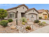 Stunning single-story home with desert landscaping, a stone path and a tile roof at 41208 N Prestancia Dr, Anthem, AZ 85086