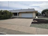 Charming single-story home with a wide driveway and attached two-car garage at 9847 W Silver Bell Dr, Sun City, AZ 85351