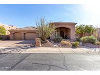 Stunning single-story home showcases desert landscaping, porte-cochere, and a three-car garage with a circular driveway at 12113 E Laurel Ln, Scottsdale, AZ 85259