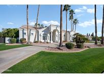 Elegant white home with palm trees, manicured lawn, and a circular driveway at 2251 N 32Nd St # 10, Mesa, AZ 85213