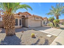 Charming single-Gathering home featuring desert landscaping, a tile roof, and an attached two-car garage at 7539 W Kimberly Way, Glendale, AZ 85308