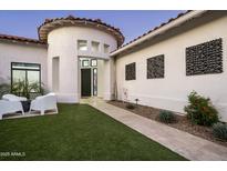 Inviting front yard featuring manicured lawn, modern seating, and stylish architectural details, perfect for outdoor relaxation at 7614 E Cactus Wren Rd, Scottsdale, AZ 85250