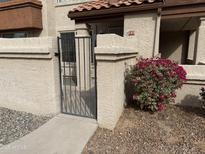Inviting stucco home with a gated front patio and vibrant red bougainvillea bush at 839 S Westwood -- # 187, Mesa, AZ 85210