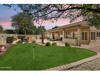 Backyard featuring a putting green, a covered patio, and mature landscaping at 8960 W Kerry Ln, Peoria, AZ 85382