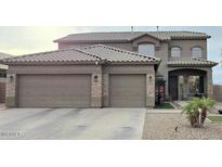 Two-story home with three-car garage, neutral stucco, stone accents, and covered front porch at 114 N 119Th Dr, Avondale, AZ 85323