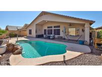 Backyard with a refreshing pool, covered patio, desert landscaping, and ample space for outdoor enjoyment at 12814 W Windrose Dr, El Mirage, AZ 85335