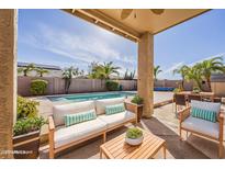Inviting pool area with comfortable seating, palm trees, and ample space for outdoor relaxation and entertainment at 14837 W Crocus Dr, Surprise, AZ 85379