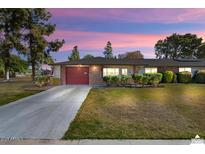 Charming single-story brick home with a well-maintained lawn and a red garage door, ideal for suburban living at 15621 N Lakeforest Dr, Sun City, AZ 85351