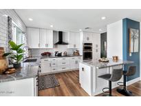 Modern kitchen with white cabinets, stainless steel appliances, and a breakfast bar at 2065 E Alameda Dr, Tempe, AZ 85282