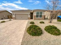 Charming single-story home featuring a well-manicured front yard and two car garage at 25912 N Langley Dr, Peoria, AZ 85383