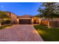 Beautiful single-Gathering home with a two-car garage, brick driveway, and manicured front yard landscaping at 29219 W Clarendon Ave, Buckeye, AZ 85396