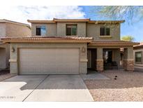 Inviting two-story home featuring a two-car garage, covered porch, and desert landscaping at 44961 W Miraflores St, Maricopa, AZ 85139