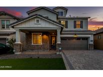 Beautiful two-story home with a brick and stone facade and a well-manicured front lawn at twilight at 717 E Deer Creek Rd, Phoenix, AZ 85048