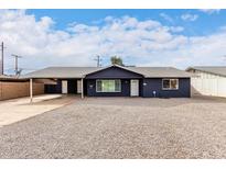 Charming single-story home featuring a low maintenance gravel yard, covered parking and a fresh modern paint job at 8014 N 55Th Ave, Glendale, AZ 85302