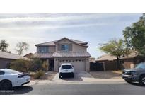 Charming two-story home with a well-maintained front yard and a two car garage and a newer vehicle at 9335 W Kingman St, Tolleson, AZ 85353