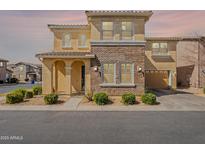 Charming two-story home featuring a brick facade, arched entry, and attached two car garage at 9918 E Tahoe Ave, Mesa, AZ 85212