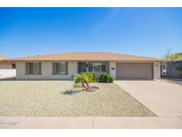 Charming single-story home featuring a gravel yard, desert landscaping, and attached two-car garage at 16413 N Orchard Hills Dr, Sun City, AZ 85351