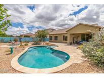 Backyard featuring a private pool and spa, desert landscaping, and a covered patio for outdoor dining at 18178 W Desert View Ln, Goodyear, AZ 85338