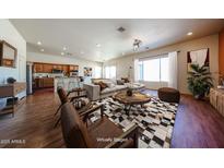 Inviting living room featuring hardwood floors, stylish furniture, and seamless access to the kitchen at 18178 W Desert View Ln, Goodyear, AZ 85338