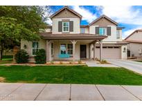 Charming two-story home with a welcoming front porch and manicured lawn at 3632 E Comstock Dr, Gilbert, AZ 85296