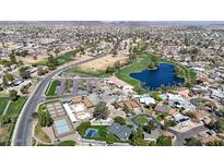 Expansive aerial view of community amenities, including a golf course, driving range, and lake, amidst residential homes at 4523 W Bluefield Ave, Glendale, AZ 85308