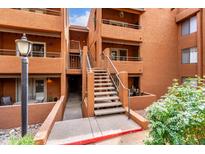 Exterior of a multi-story condo complex with staircase access to units and red brick facade at 4704 E Paradise Village Pkwy # 213, Phoenix, AZ 85032