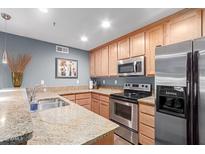 A kitchen features granite countertops, stainless steel appliances, and hardwood cabinets at 4704 E Paradise Village Pkwy # 213, Phoenix, AZ 85032