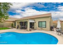 Beautiful backyard featuring a sparkling pool, covered patio, and lush landscaping for outdoor enjoyment at 9212 W Salter Dr, Peoria, AZ 85382