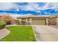 Well-maintained single-story home with a two-car garage, lush lawn, and desert landscaping at 9212 W Salter Dr, Peoria, AZ 85382