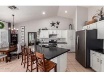 Modern kitchen with stainless steel appliances, white cabinetry, and an island with bar seating at 9212 W Salter Dr, Peoria, AZ 85382