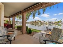 Inviting covered back patio overlooking a serene lake, perfect for relaxing and entertaining outdoors at 1306 N Palmsprings Dr, Gilbert, AZ 85234