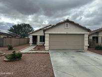 Charming single-story home featuring a two-car garage and low-maintenance landscaping in a quiet neighborhood at 15023 W Caribbean Ln, Surprise, AZ 85379
