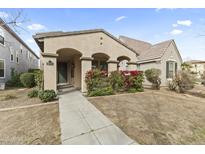 Charming single-story home with a cozy front porch and well-maintained landscaping, enhancing its curb appeal at 15469 W Dreyfus St, Surprise, AZ 85379