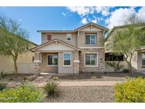 Attractive two-story home with stone and siding accents, well-manicured landscaping, and sunny curb appeal at 29243 N 122Nd Ln, Peoria, AZ 85383