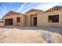 New home construction featuring wood framing, and a spacious two-car garage under a blue, partly cloudy sky at 4115 E Windsor Ave, Phoenix, AZ 85008