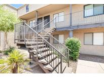 Condo exterior with tan stucco, metal stair railings, and lush desert landscaping at 5995 N 78Th St # 2079, Scottsdale, AZ 85250