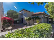 Charming home featuring desert landscaping, a brick walkway, and a cozy, enclosed two-car garage at 10557 E Fanfol Ln, Scottsdale, AZ 85258