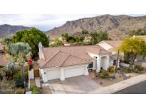 Charming single-story home with a tile roof, three-car garage, mountain view, and well-manicured landscaping at 1356 E Desert Flower Ln, Phoenix, AZ 85048