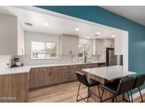 Modern kitchen featuring a breakfast bar, updated cabinets, countertops and stainless steel appliances at 1824 W State Ave, Phoenix, AZ 85021