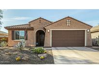 Charming home featuring desert landscaping, a two-car garage, and a cozy, covered entryway at 21362 N 260Th Ln, Buckeye, AZ 85396