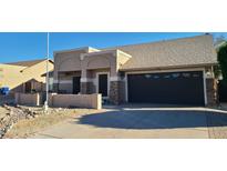 Inviting home featuring a two-car garage, desert landscaping, and a neutral color palette at 4865 E Princess Dr, Mesa, AZ 85205