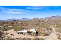 Expansive aerial view of desert home with mountain backdrop, surrounded by mature saguaro cacti and desert vegetation at 8115 E Paint Pony Dr, Carefree, AZ 85377